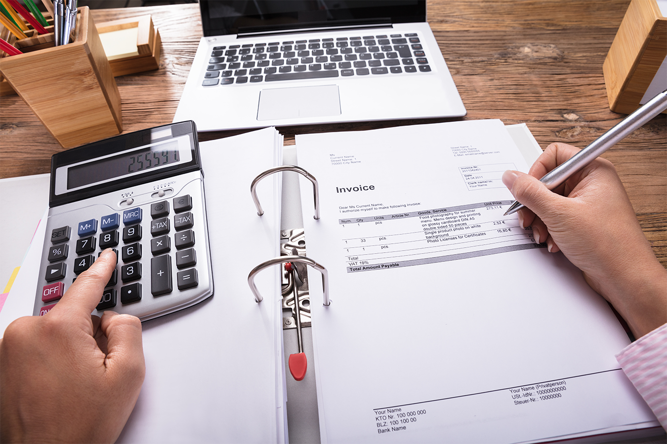 Person der sidder med en lommeregner og regner på en faktura